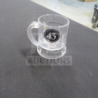 Clear plastic shot glass with "Licor 43" logo, handle, and durable construction. Appears in excellent condition.