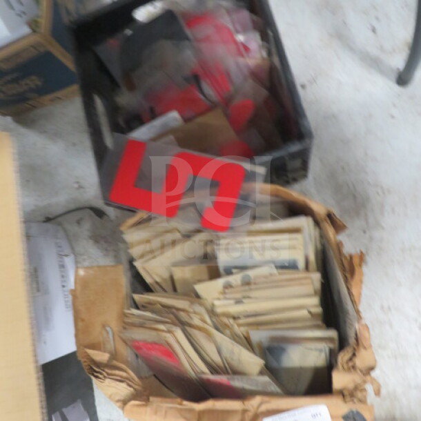 A collection of 10-inch red letters and numbers, stored in boxes. Some items are loose with visible wear.