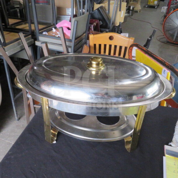 Stainless steel oval chafer with gold accent, in good condition; features decorative gold handles and knob.