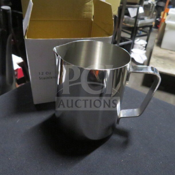 NEW 12oz stainless steel frothing pitcher with handle, next to its box. Brand: 2XBID. Pristine condition.