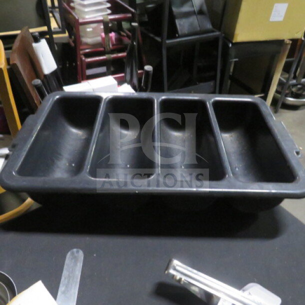 Black plastic flatware holder with four compartments, used condition, ideal for organizing cutlery in kitchens or dining areas.
