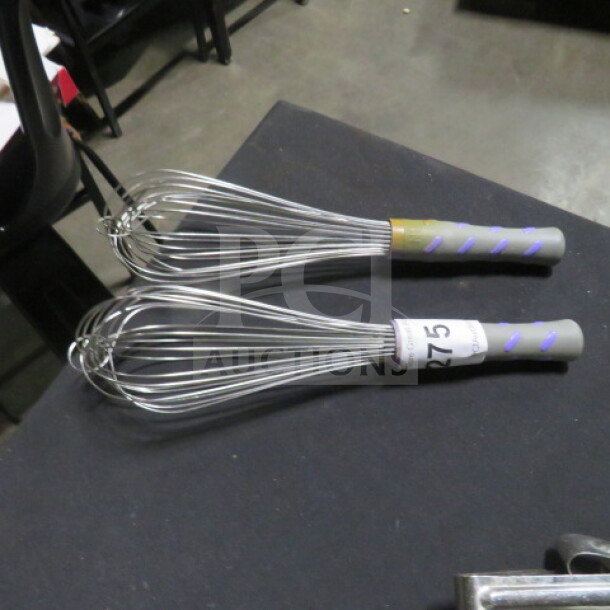 Two commercial whisks with gray handles and metal wires, labeled "R275," in good condition.