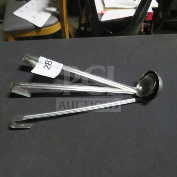 Assorted size stainless steel ladles on display table, labeled "28". Set includes three ladles in good condition.