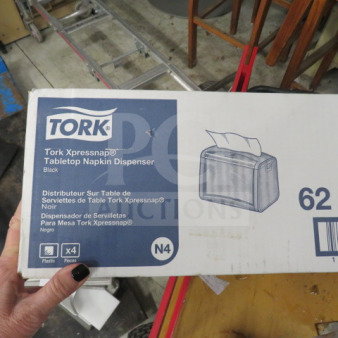 Brand new Tork Xpressnap tabletop napkin dispenser in box. Black color, model N4, includes 4 plastic dispensers.