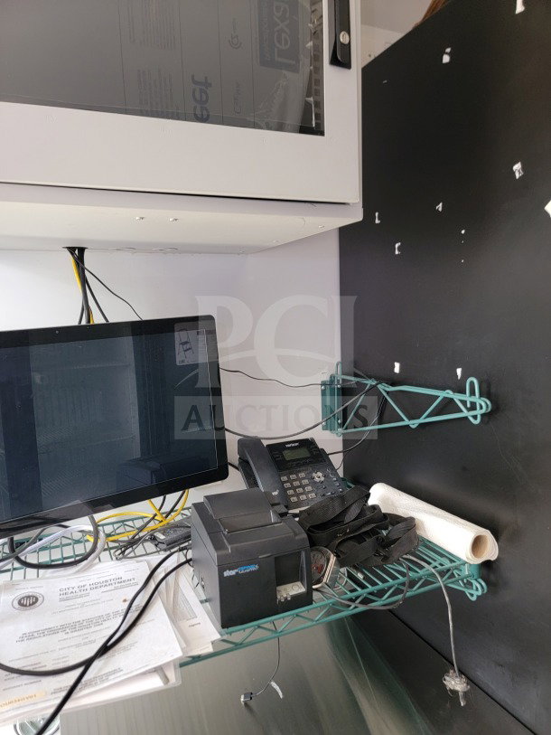 Interior of 2021 SDG 8.5' x 20' mobile trailer with POS workstation. Visible are a monitor, printer, phone, and documents.