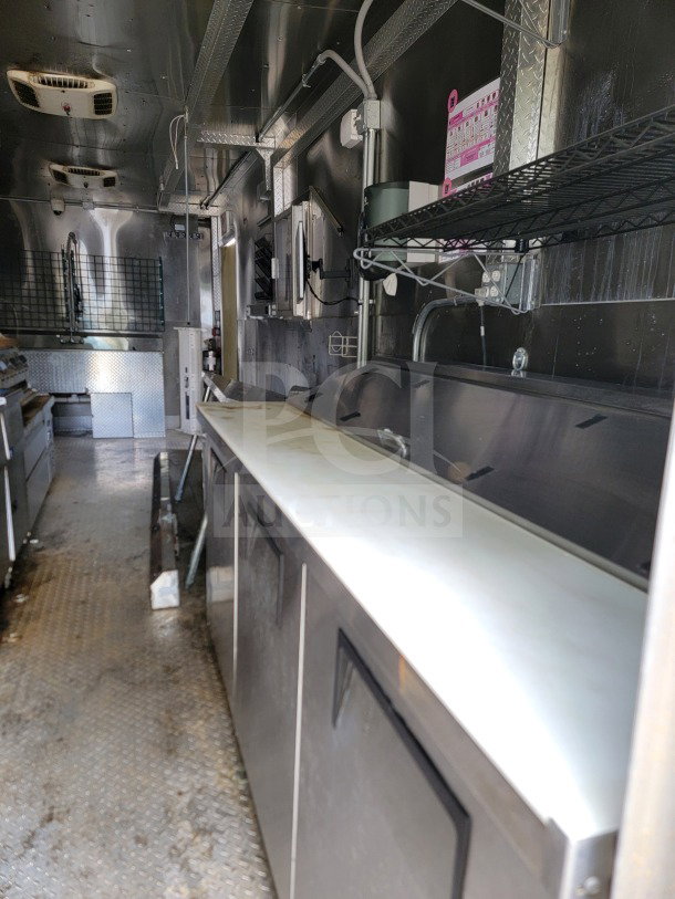 2021 Diamond Cargo 8.5' x 24' mobile kitchen trailer interior with stainless counters, NAKS hood, and refrigeration units.