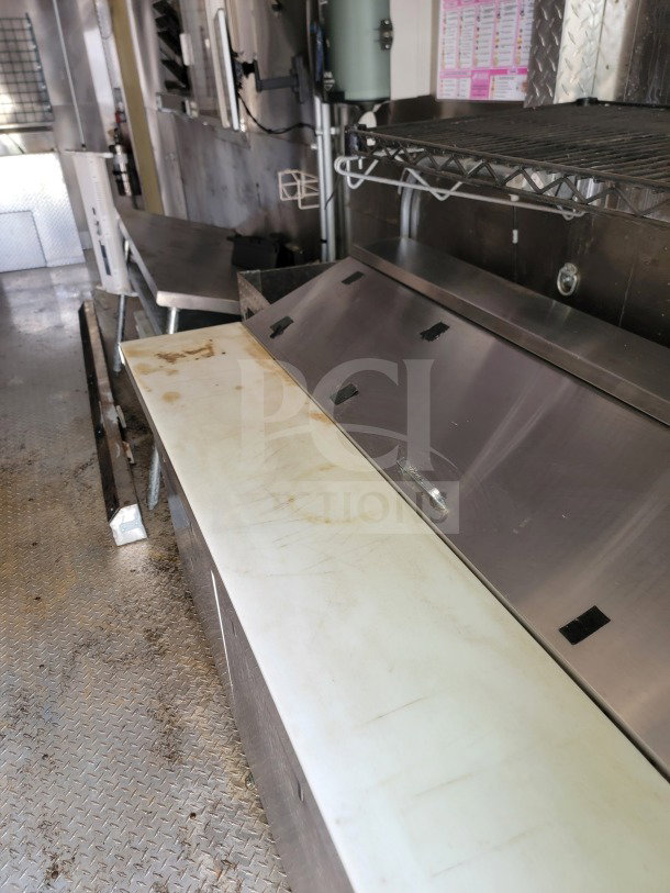 Interior of 2021 Diamond Cargo 8.5' x 24' mobile kitchen trailer, featuring stainless steel counters and shelving.