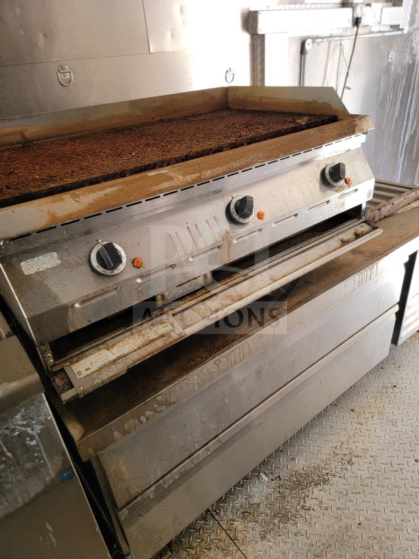 Tandem-Axle Mobile Kitchen Trailer featuring worn griddle and two control knobs. Model 24 by Diamond Cargo.