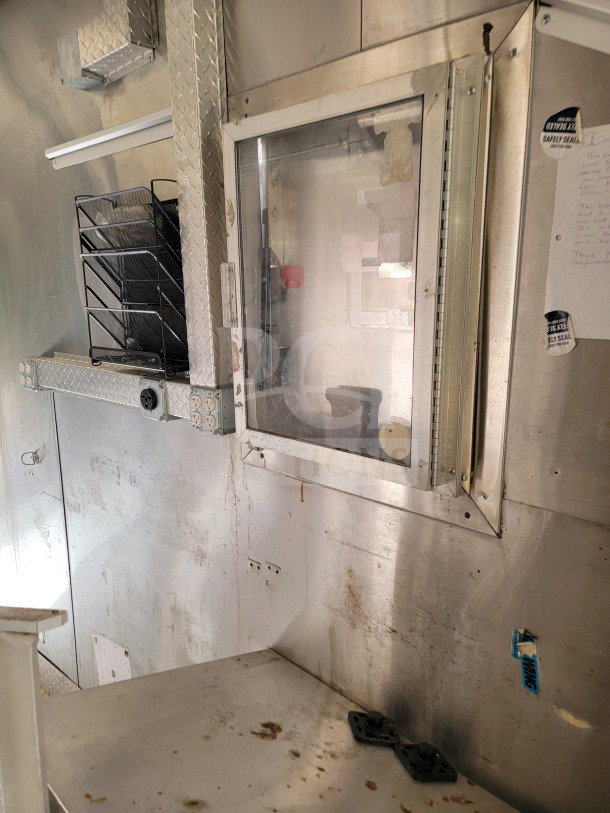 2021 Diamond Cargo Mobile Kitchen Trailer with aluminum interior, service window, electrical outlets, and shelving. Signs of wear.