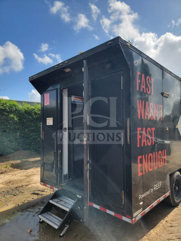 2021 SDG 8.5' x 20' dual-axle mobile kitchen trailer, black exterior, CaptiveAire hood, True refrigeration, open door.