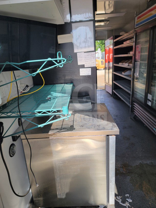 2021 SDG 8.5' x 20' mobile kitchen trailer interior, featuring a stainless steel counter, CaptiveAire hood, and True refrigeration.