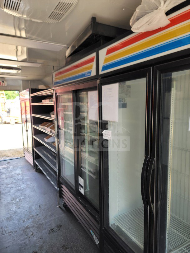 2021 SDG 8.5' x 20' mobile kitchen trailer interior, featuring True refrigeration, shelving, and CaptiveAire hood.