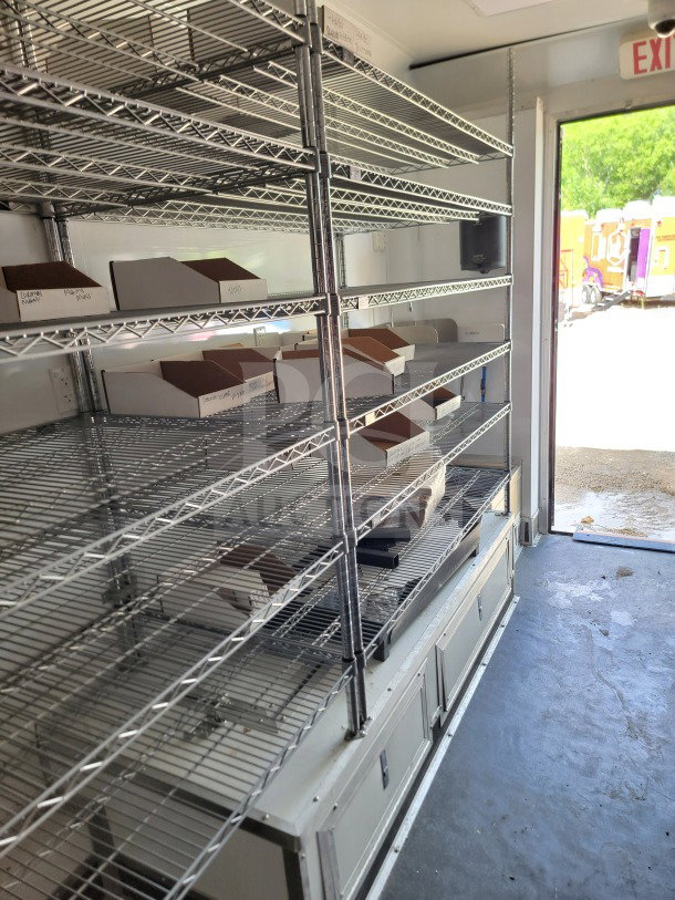 2021 SDG 8.5' x 20' mobile kitchen trailer interior with wire shelving, labeled boxes, and storage cabinets; clean condition.