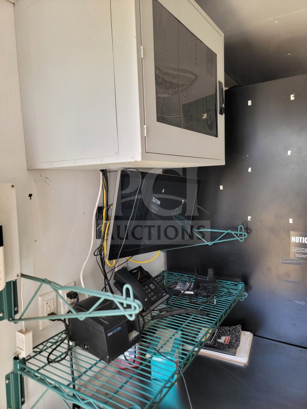 Interior view of 2021 SDG 8.5' x 20' trailer with refrigeration suite, featuring shelving, monitor, and communication equipment.