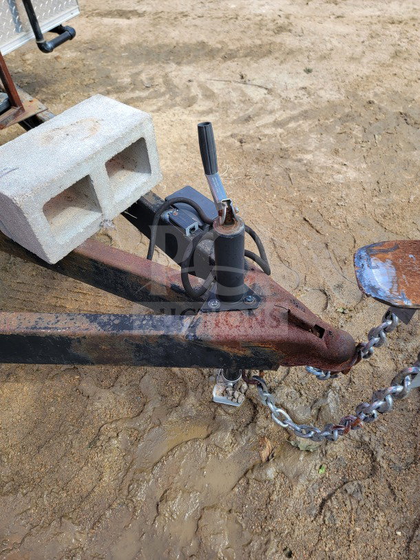 Trailer hitch of 2021 Rock Solid Cargo 8.5' x 24' mobile kitchen trailer. Rust present, includes cinder block and chains.