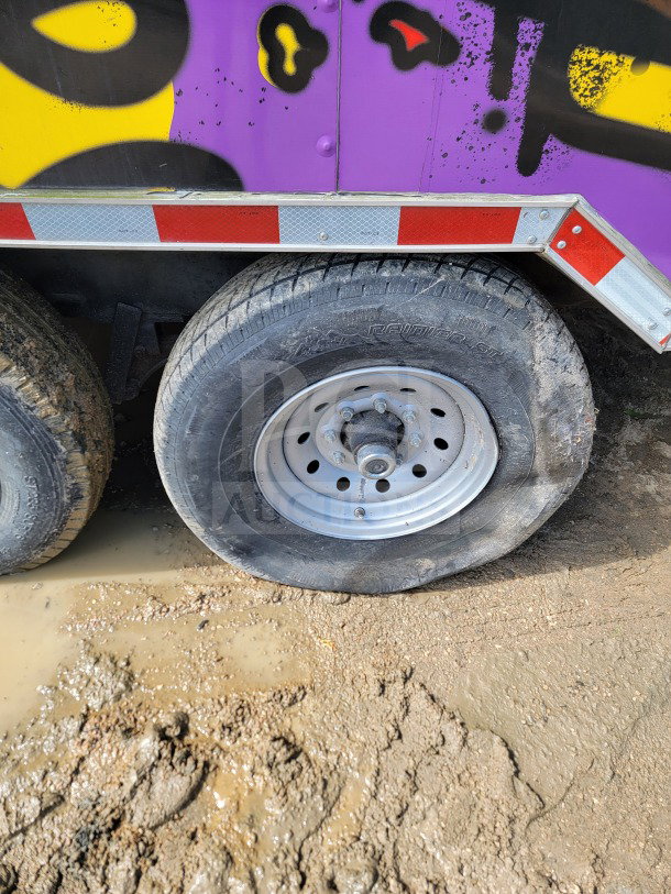 2021 Rock Solid Cargo dual-axle wheel detail with painted exterior. Tire in used condition; visible mud.