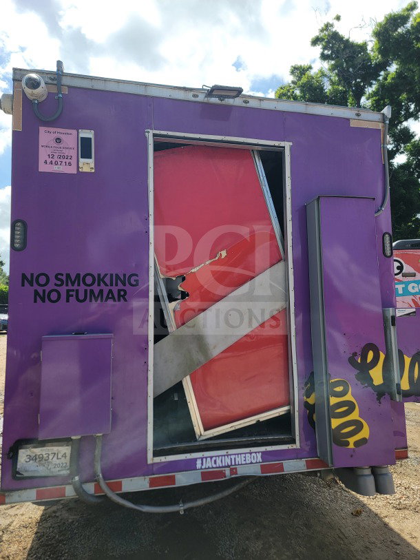 2021 Rock Solid Cargo mobile kitchen trailer with damaged rear door, purple exterior, and #JACKINTHEBOX branding.