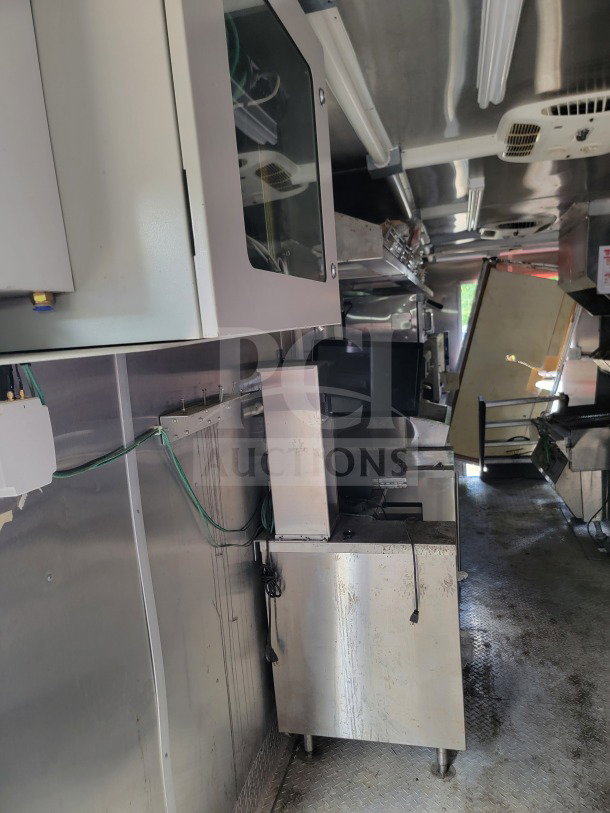2021 Rock Solid Cargo 8.5' x 24' mobile kitchen trailer interior, featuring stainless equipment, CaptiveAire hood, and refrigeration units.