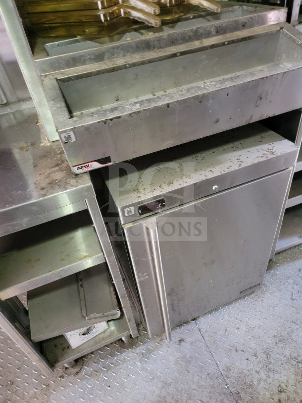 2021 Rock Solid Cargo Mobile Kitchen Trailer interior, featuring stainless steel shelves, APW label, visible wear.