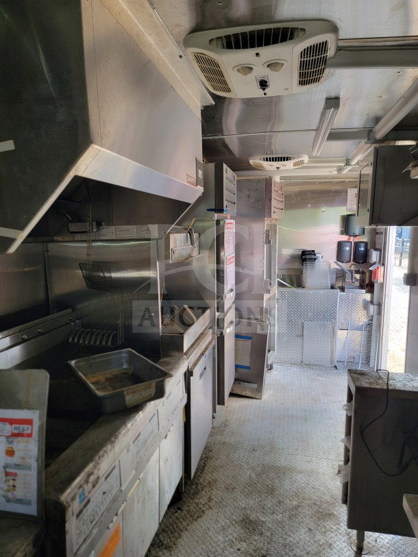 2021 Rock Solid Cargo 8.5' x 24' mobile kitchen trailer interior with CaptiveAire hood, refrigeration units, and cooking equipment.