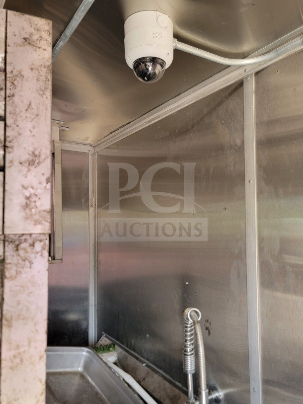 Interior of 2021 Rock Solid Cargo kitchen trailer with stainless steel surfaces, visible plumbing, camera, and exhaust duct.