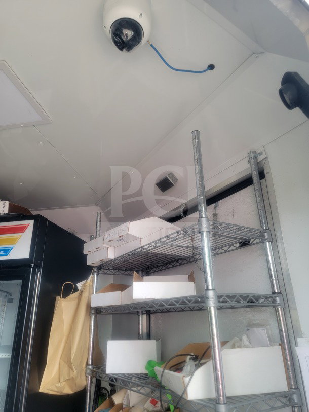 Interior of 2021 SDG 8.5' x 20' trailer featuring metal shelves, boxes labeled 'Birthday Cake,' and cold-chain storage.