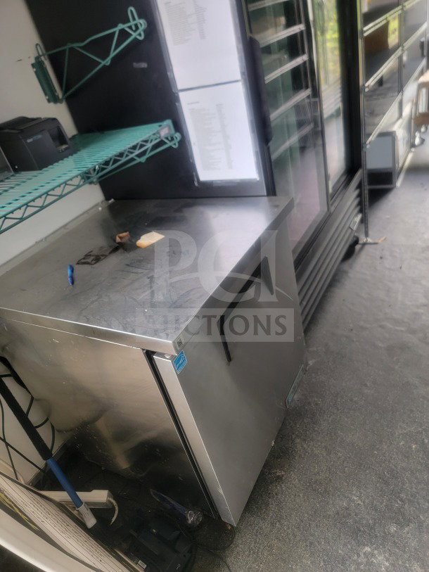 Interior of 2021 SDG 8.5' x 20' trailer with custom cold-chain storage. Features True glass-door refrigeration and shelving.