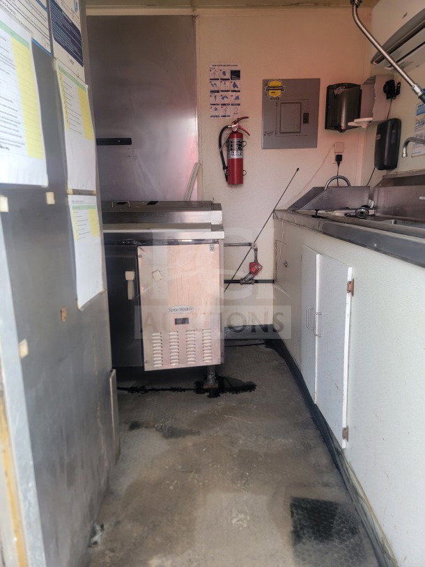 2021 Rock Solid Cargo 8.5' x 24' mobile ghost kitchen trailer; interior showing Serv-Ware refrigeration, fire extinguisher, and sink.