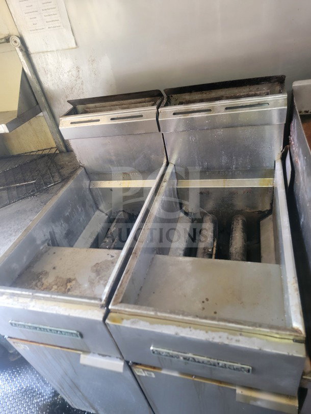 2021 Rock Solid Cargo mobile kitchen trailer interior with dual fryers. Stainless steel, used condition, visible wear.