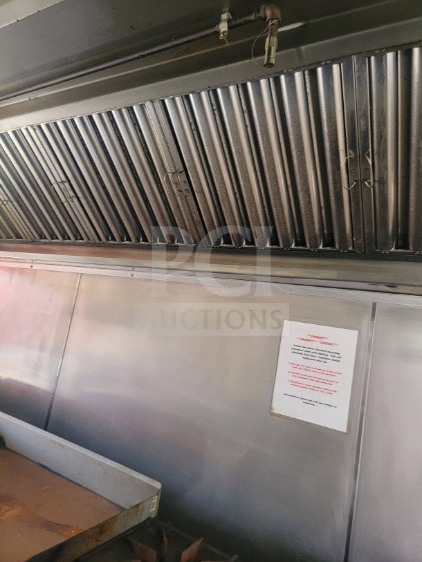 Interior view of a 2021 Rock Solid Cargo Ghost Kitchen Trailer featuring a stainless steel vent hood and service instructions on the wall.