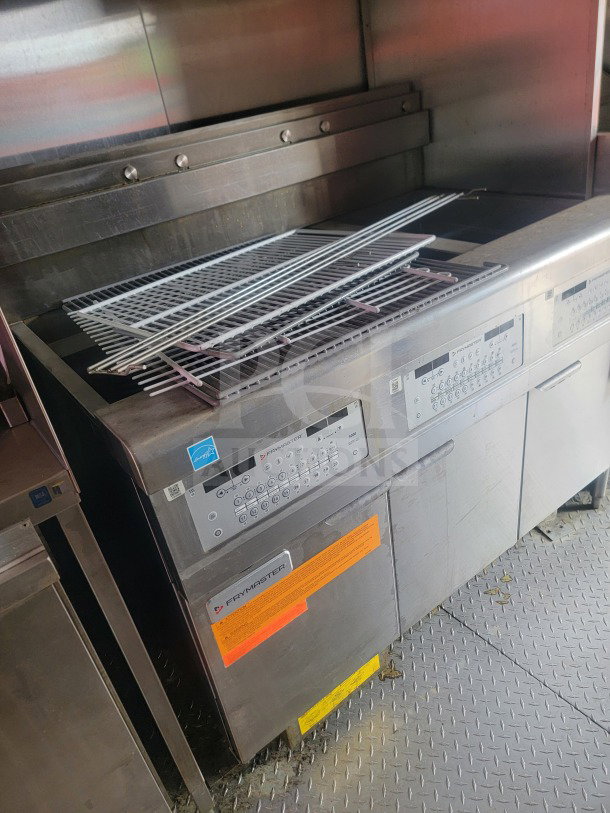 Interior view of LOT #8 2021 Titanium Cargo mobile kitchen trailer featuring Frymaster equipment, including control panels and ventilation.