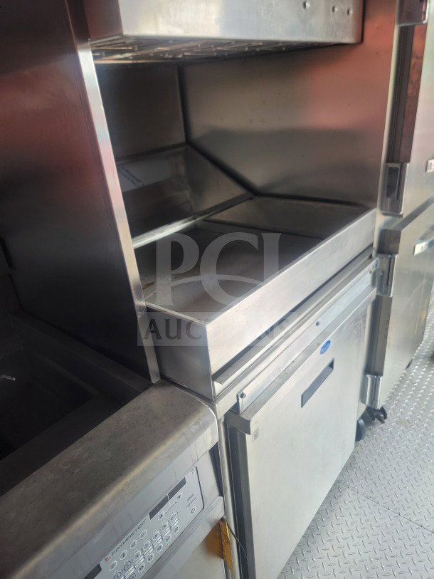 2021 Titanium Cargo 8.5' x 24' mobile QSR kitchen trailer interior showing stainless steel appliances, CaptiveAire ventilation, and cold storage units.
