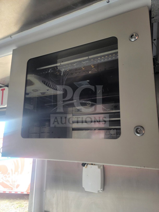 Interior view of a 2021 Titanium Cargo mobile kitchen trailer, featuring a secured network equipment cabinet with visible wiring.