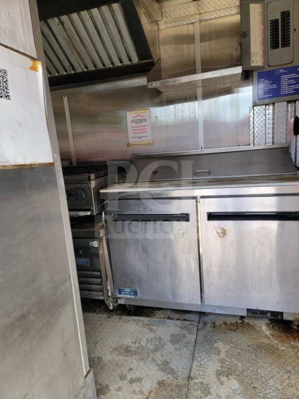 Diamond Cargo mobile kitchen trailer interior, featuring Arctic Air storage, stainless steel surfaces, and Wells cooking line.