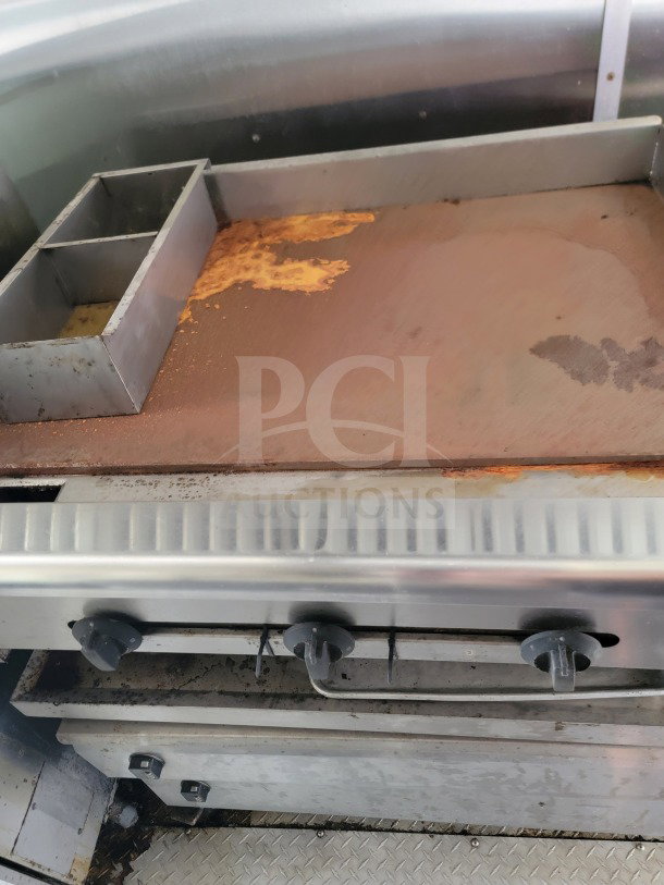 Rusted cooking surface inside a 2019 Diamond Cargo mobile kitchen trailer showing signs of wear.