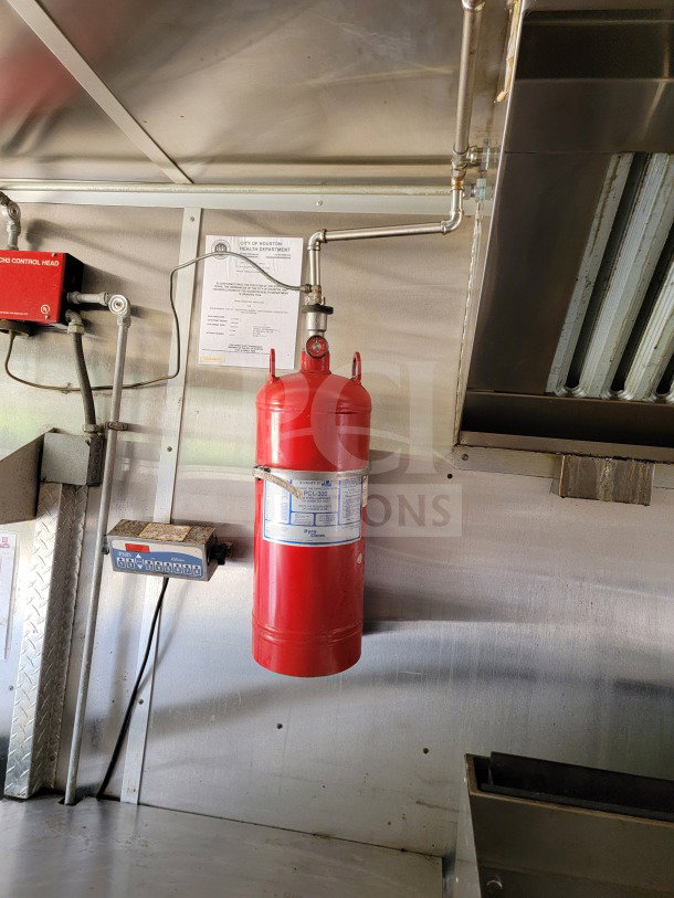 2019 Diamond Cargo mobile kitchen trailer interior; features red fire extinguisher, health department inspection notice, and stainless steel walls.