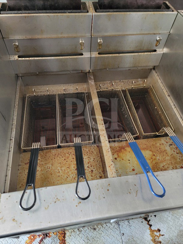 Deep fryer section of a 2019 Diamond Cargo mobile kitchen trailer, featuring multiple fryer baskets on a stainless steel surface.