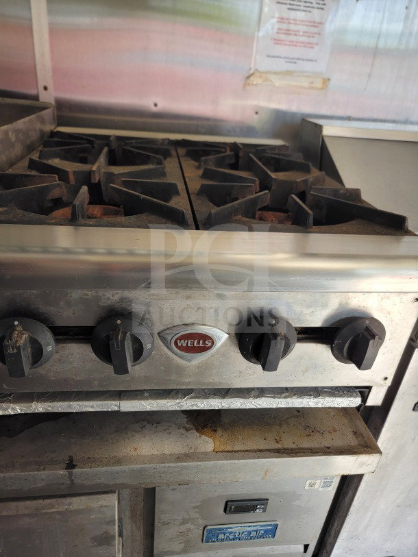 Close-up of a Wells cooking range in used condition, part of a 2019 Diamond Cargo 24' mobile kitchen trailer.