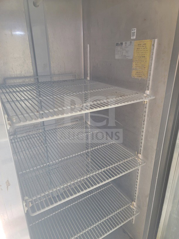 Interior of Arctic Air storage unit inside 2019 Diamond Cargo 8.5' x 24' kitchen trailer, featuring metal shelves and labels.