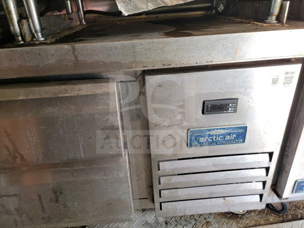 Arctic Air commercial refrigerator in a 2019 Diamond Cargo mobile kitchen trailer. Visible wear on metal surface.
