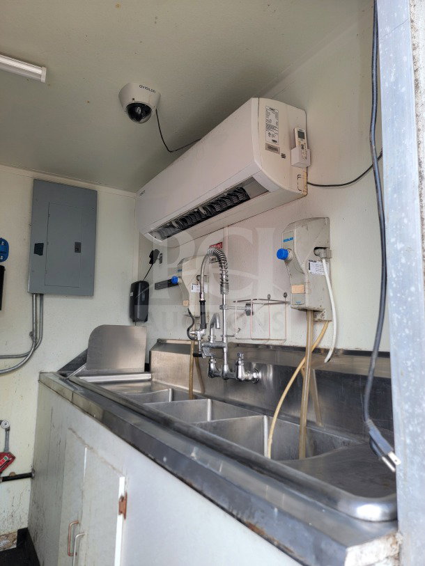 2019 Diamond Cargo 8.5' x 24' mobile kitchen trailer interior, featuring triple sink, wall unit, and surveillance camera.