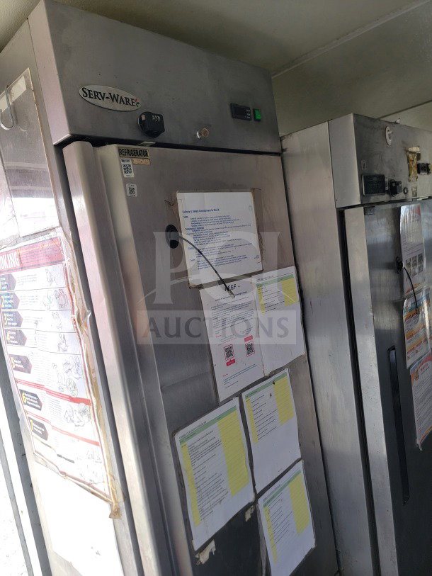 Serv-Ware refrigerator inside Diamond Cargo mobile kitchen trailer with attached safety instruction documents.