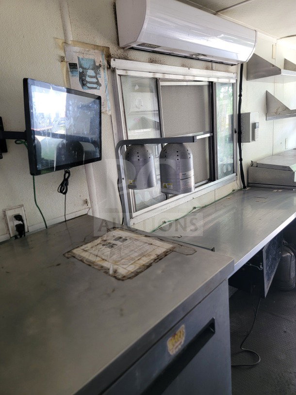 2019 Diamond Cargo 8.5' x 24' mobile kitchen trailer interior, featuring stainless steel surfaces, a wall-mounted monitor, and ventilation.