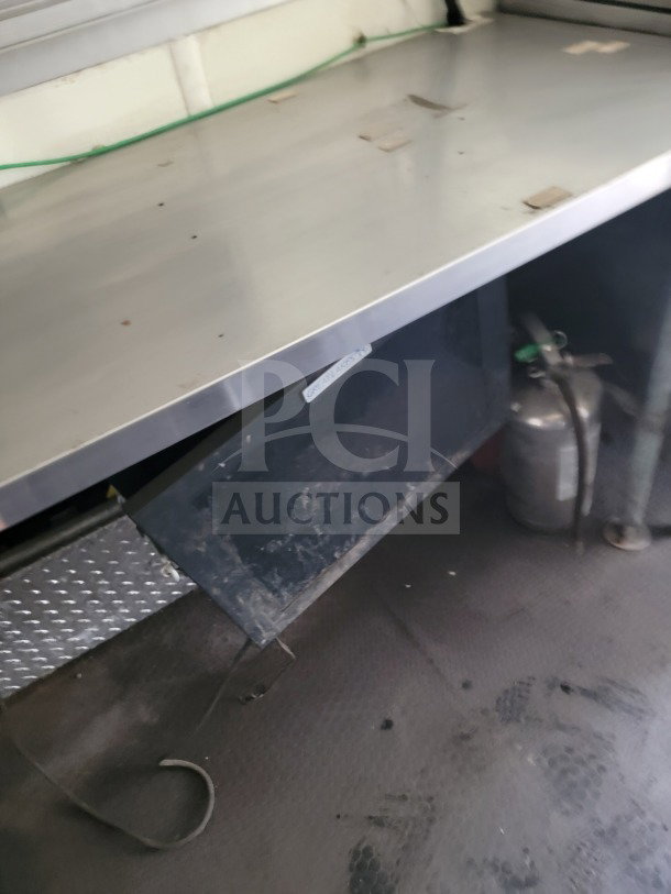 Interior view of 2019 Diamond Cargo mobile kitchen trailer. Features stainless steel counter, Globe Electric Griddle, and fire extinguisher.