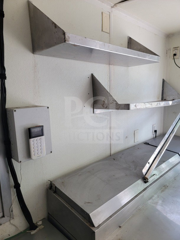 Interior of a 2019 Diamond Cargo mobile kitchen trailer showing stainless steel shelves and keypad control panel.