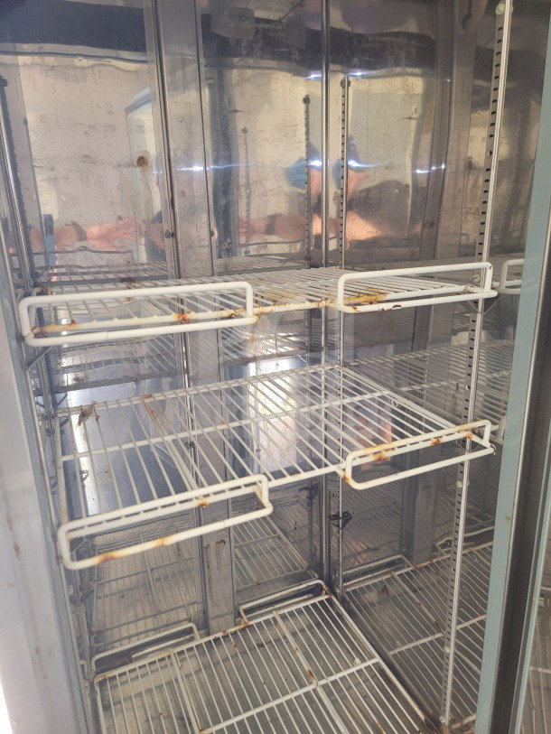 Interior view of a 2019 Diamond Cargo 8.5' x 24' mobile kitchen trailer, featuring metal shelving with visible rust.