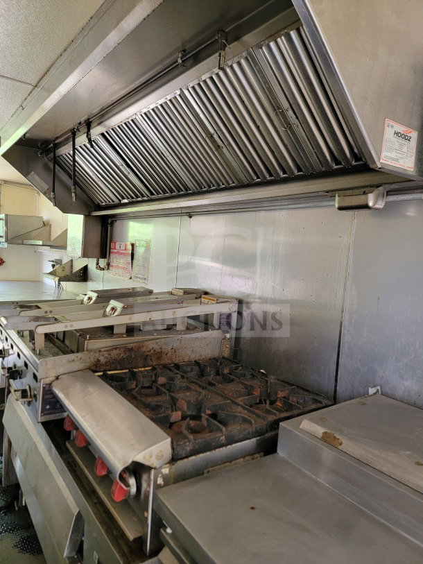 2019 Diamond Cargo mobile kitchen trailer interior with industrial stove, ventilation hood, and Serv-Ware setup.