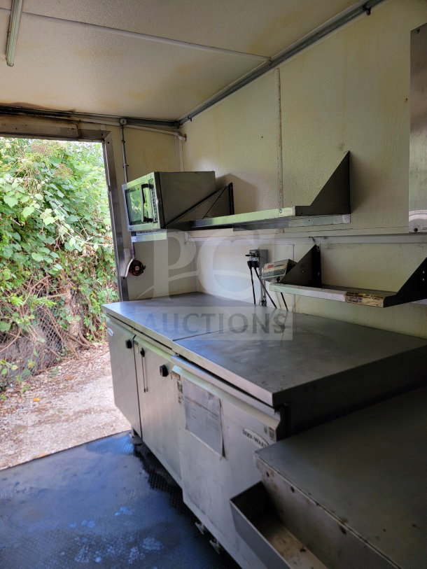 Interior view of Diamond Cargo mobile kitchen trailer, showing Serv-Ware refrigeration units and countertop space.