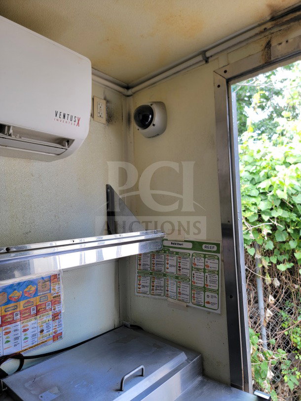 Interior of 2019 Diamond Cargo kitchen trailer showing VentusX inverter, overhead shelving, and menu charts on the wall.