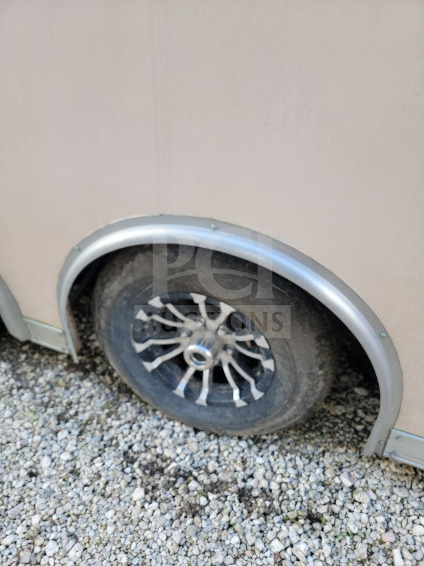 2021 Forest River 8.5' x 24' trailer wheel, tandem-axle, dirt surface, partial side panel visible.